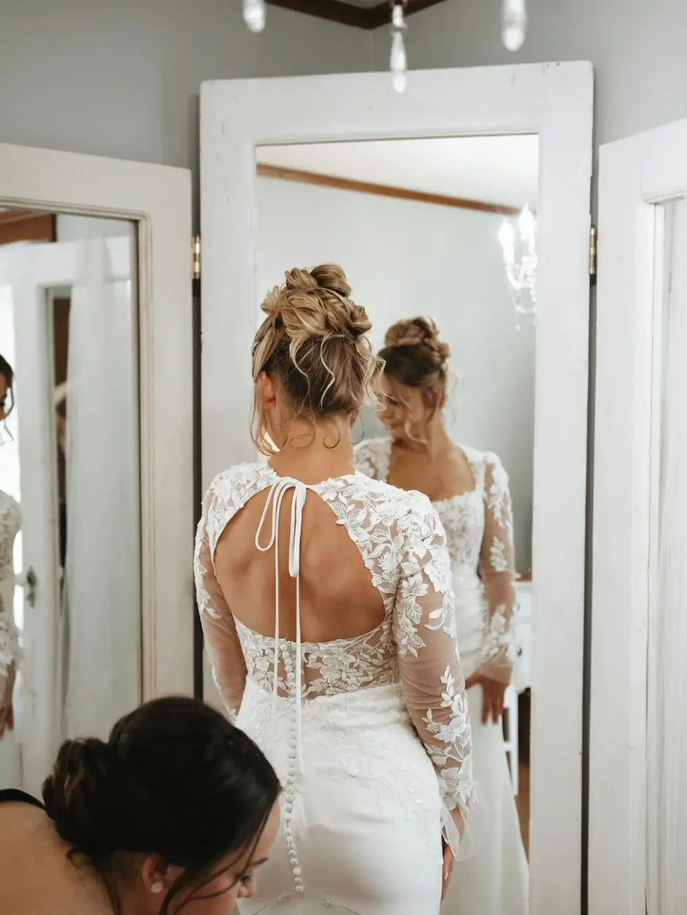 A bride turning to see the back of her altered gown in the mirror at CleanMeNow